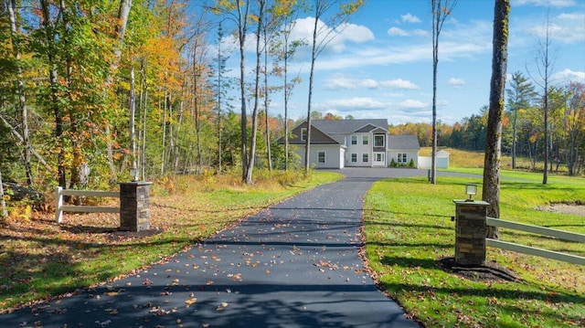 view of front of property with aphalt driveway, fence, and a front yard