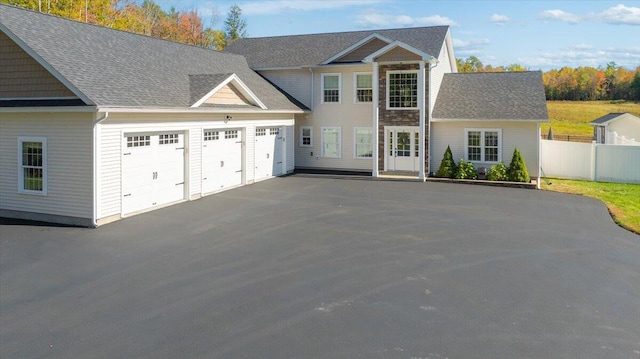 colonial home featuring a garage, fence, and driveway