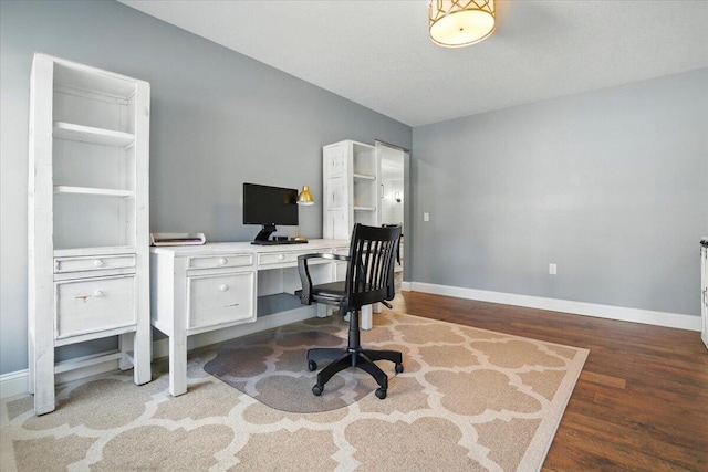 office space with baseboards, wood finished floors, and vaulted ceiling