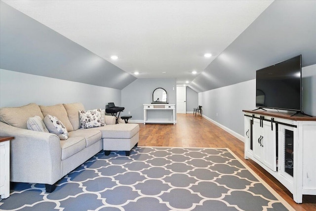 living room featuring baseboards, lofted ceiling, and wood finished floors