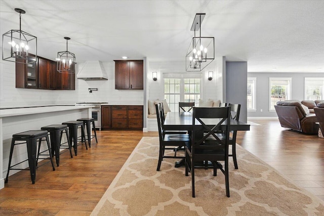 dining space featuring an inviting chandelier, baseboards, plenty of natural light, and wood finished floors