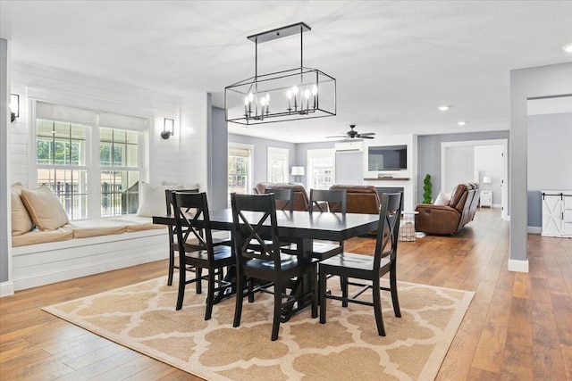 dining space with baseboards, ceiling fan with notable chandelier, recessed lighting, and hardwood / wood-style floors