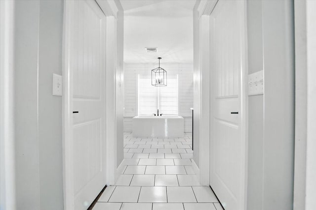 hall with tile patterned floors