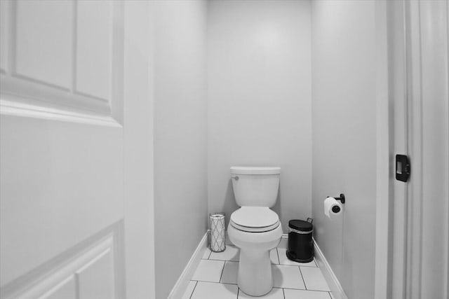 bathroom with baseboards, tile patterned floors, and toilet