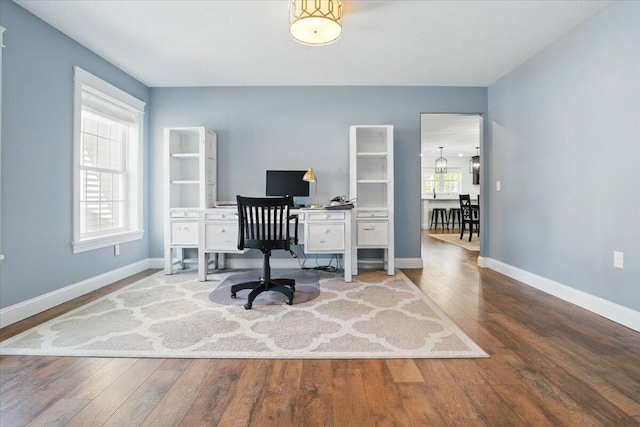 home office with baseboards, a wealth of natural light, and hardwood / wood-style floors