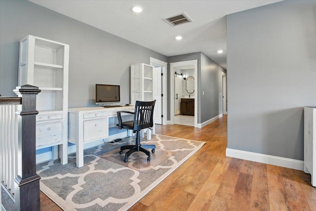 office featuring baseboards, recessed lighting, light wood-style flooring, and visible vents