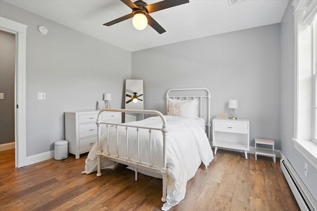 bedroom featuring ceiling fan, wood finished floors, baseboards, a baseboard radiator, and lofted ceiling
