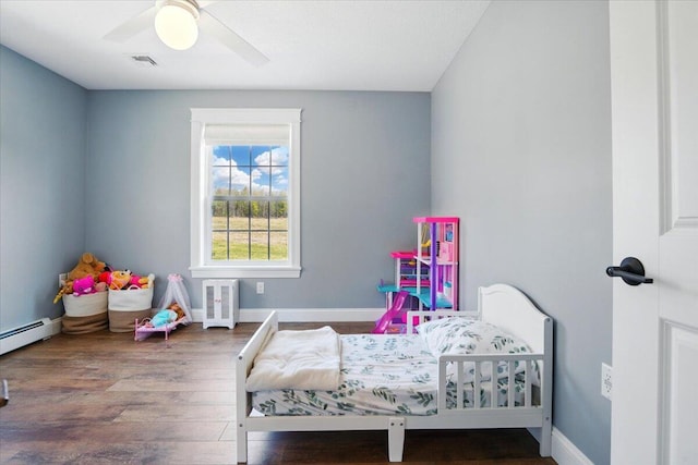 bedroom with baseboards, a baseboard radiator, wood finished floors, and visible vents