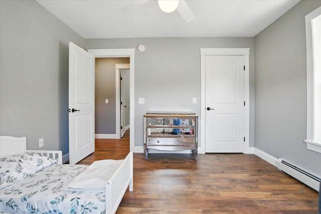 bedroom with baseboards, ceiling fan, wood finished floors, and a baseboard radiator