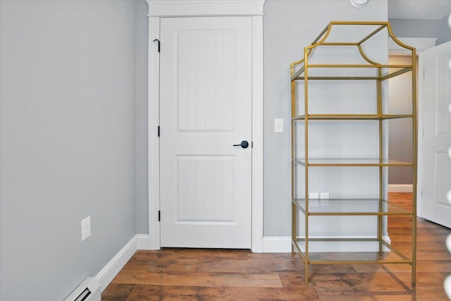 unfurnished bedroom featuring baseboards, a baseboard radiator, and wood finished floors