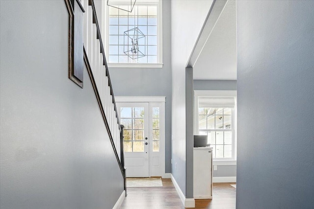 foyer entrance featuring stairs, baseboards, and wood finished floors