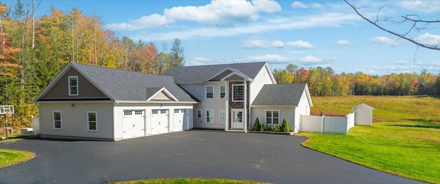 view of front facade with a garage, fence, driveway, and a front yard