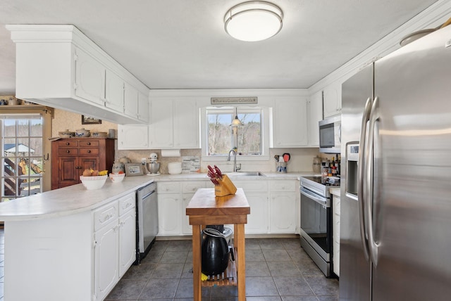 205 Patterson Rd, Limerick, ME 04048 - kitchen featuring a peninsula, appliances with stainless steel finishes, white cabinetry, and a sink