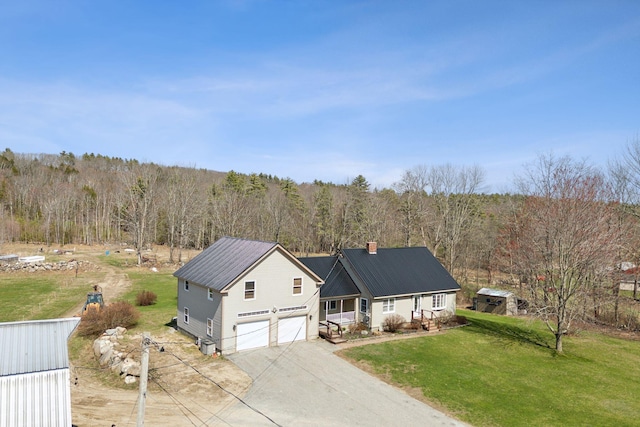 205 Patterson Rd, Limerick, ME 04048 - view of front of property featuring a garage, a view of trees, driveway, and a front yard