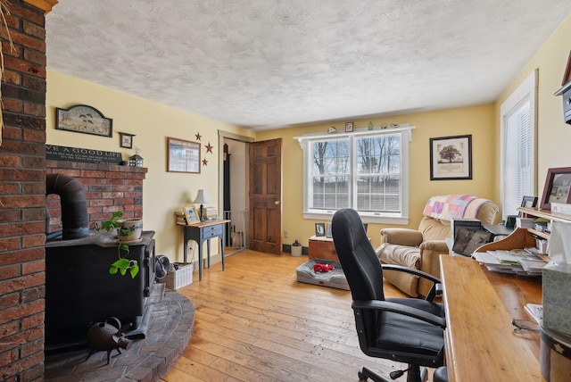 205 Patterson Rd, Limerick, ME 04048 - office space featuring wood-type flooring, a wood stove, and a textured ceiling
