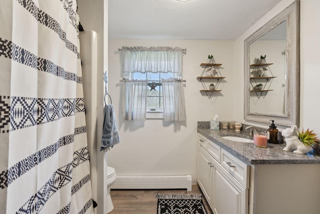 205 Patterson Rd, Limerick, ME 04048 - bathroom featuring wood finished floors, vanity, baseboards, a baseboard heating unit, and toilet