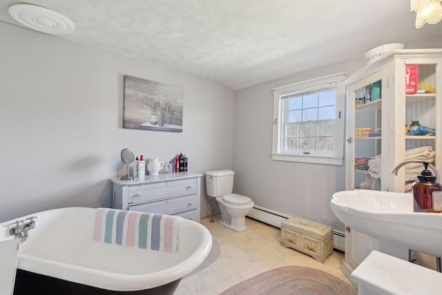 205 Patterson Rd, Limerick, ME 04048 - full bath with baseboard heating, tile patterned floors, a baseboard radiator, toilet, and a soaking tub