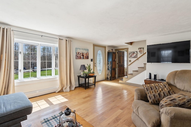 205 Patterson Rd, Limerick, ME 04048 - living room with stairway, light wood-style floors, and a baseboard heating unit