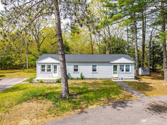 518 Ossipee Trl E, Gorham, ME 04038 - view of front of home featuring a storage shed, an outdoor structure, entry steps, a chimney, and roof with shingles