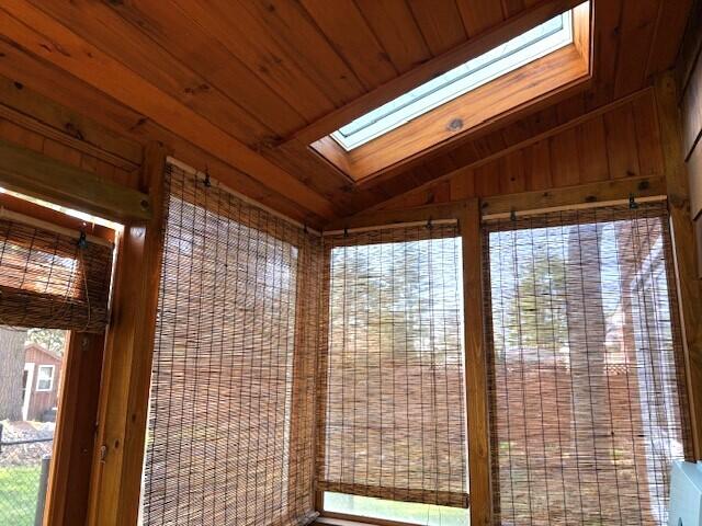 interior space with a skylight and wood ceiling