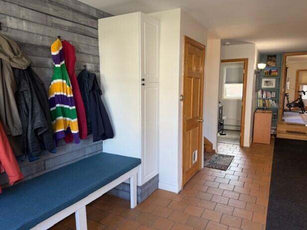 mudroom featuring wooden walls and tile patterned floors