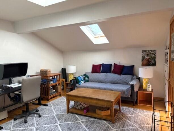office area featuring wood finished floors and lofted ceiling with skylight