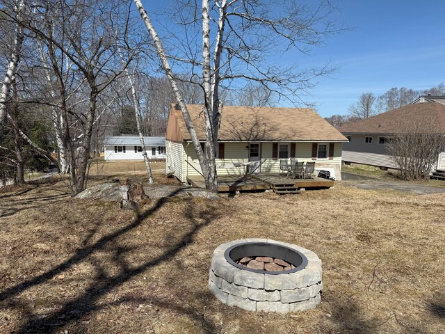 47 New Jersey St, Millinocket, ME 04462 - back of property with a fire pit, covered porch, and a chimney