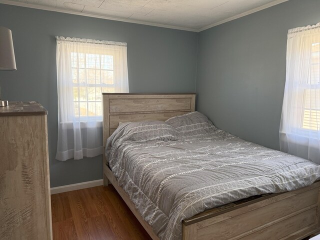 47 New Jersey St, Millinocket, ME 04462 - bedroom featuring crown molding, multiple windows, wood finished floors, and baseboards