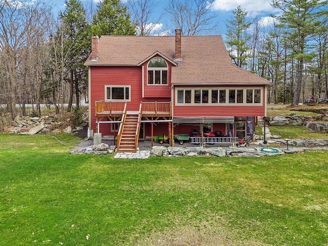 rear view of property with a lawn, a chimney, stairs, and a wooden deck