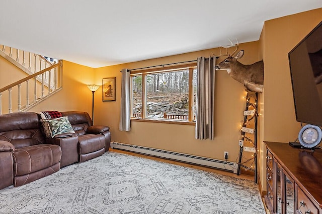 living area with wood finished floors, stairs, and a baseboard heating unit