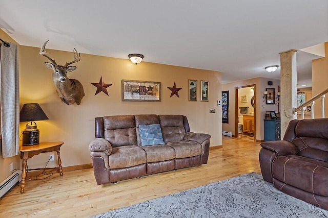 living room with wood finished floors, a baseboard radiator, baseboards, and a baseboard heating unit