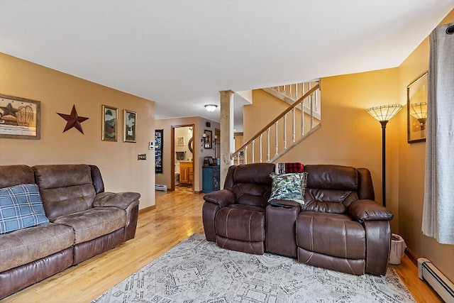 living area with baseboards, stairs, wood finished floors, and baseboard heating