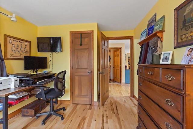 home office featuring baseboards and light wood-style flooring