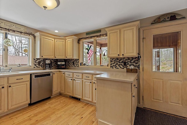 kitchen with a sink, light brown cabinetry, light wood-style flooring, and dishwasher