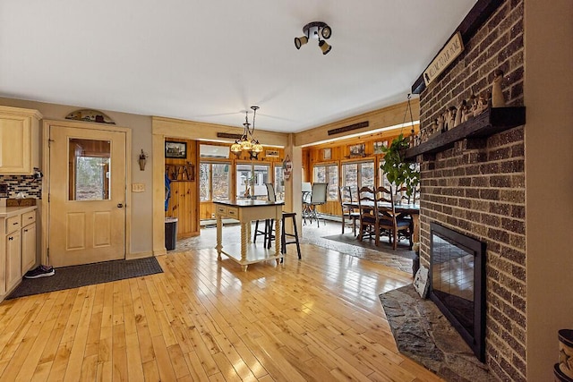 dining area featuring light wood finished floors, a healthy amount of sunlight, and a fireplace