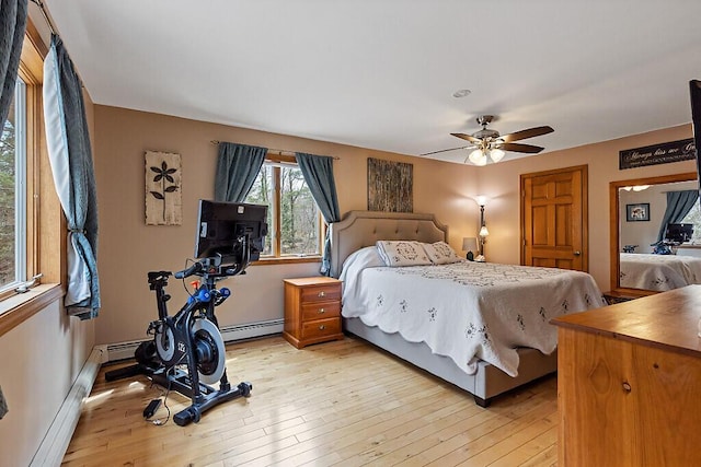bedroom with light wood-style floors and a baseboard heating unit