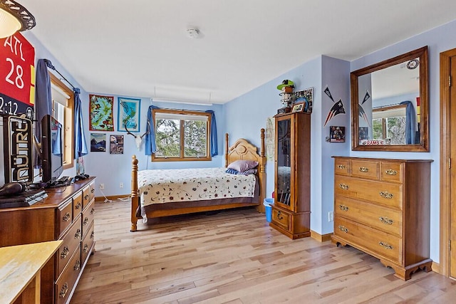 bedroom with baseboards and light wood finished floors