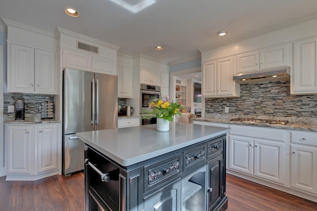 kitchen with visible vents, appliances with stainless steel finishes, tasteful backsplash, white cabinets, and under cabinet range hood