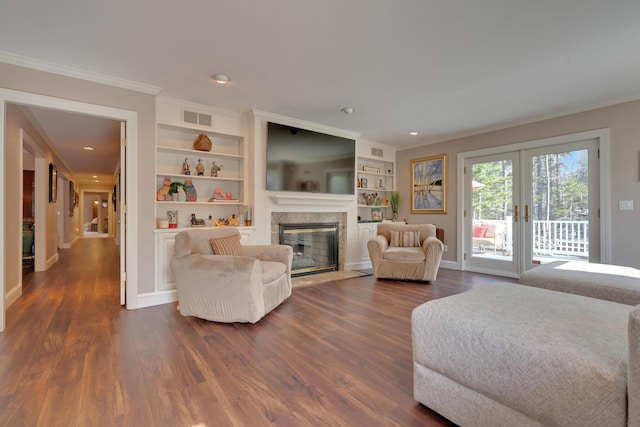 living room with french doors, dark wood-type flooring, a premium fireplace, and visible vents