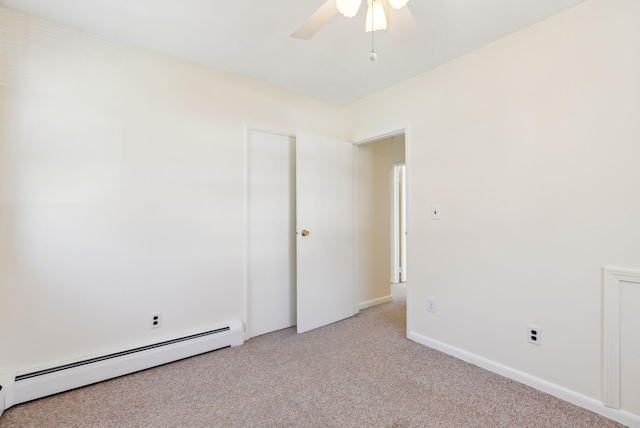 empty room featuring light colored carpet, ceiling fan, a baseboard heating unit, and baseboards