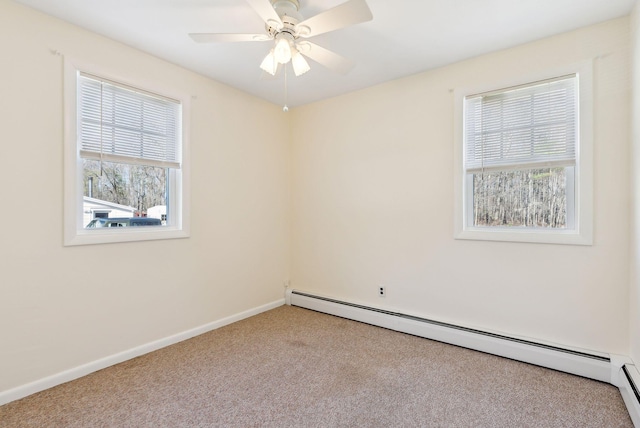 carpeted empty room featuring a ceiling fan, baseboards, and a baseboard heating unit
