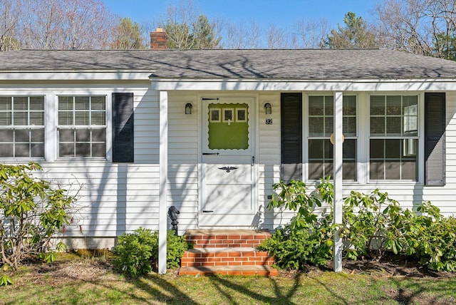 view of front of home with a shingled roof and a chimney