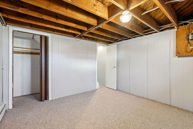 finished below grade area featuring carpet floors and a baseboard heating unit