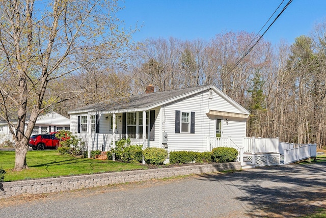 single story home with a front lawn, covered porch, and a chimney