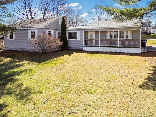 back of property featuring a porch, a chimney, and a lawn