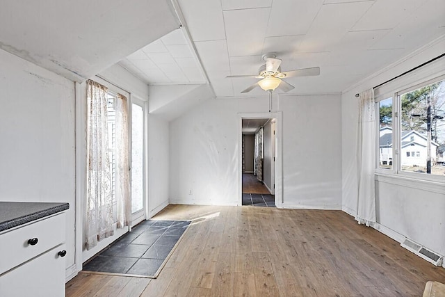 unfurnished dining area with ceiling fan, visible vents, and hardwood / wood-style floors
