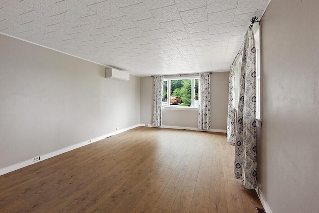 10 Field St, Bangor, ME 04401 - unfurnished room with a wall mounted AC, hardwood / wood-style floors, and baseboards