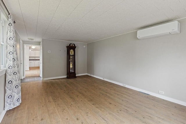 10 Field St, Bangor, ME 04401 - empty room featuring a wall mounted AC, wood finished floors, and baseboards