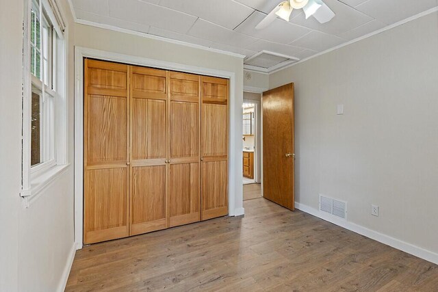 10 Field St, Bangor, ME 04401 - unfurnished bedroom featuring ornamental molding, baseboards, light wood-type flooring, a closet, and a ceiling fan