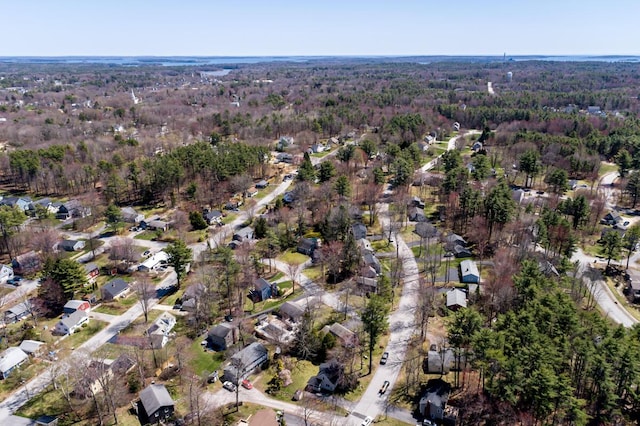 drone / aerial view featuring a residential view and a wooded view